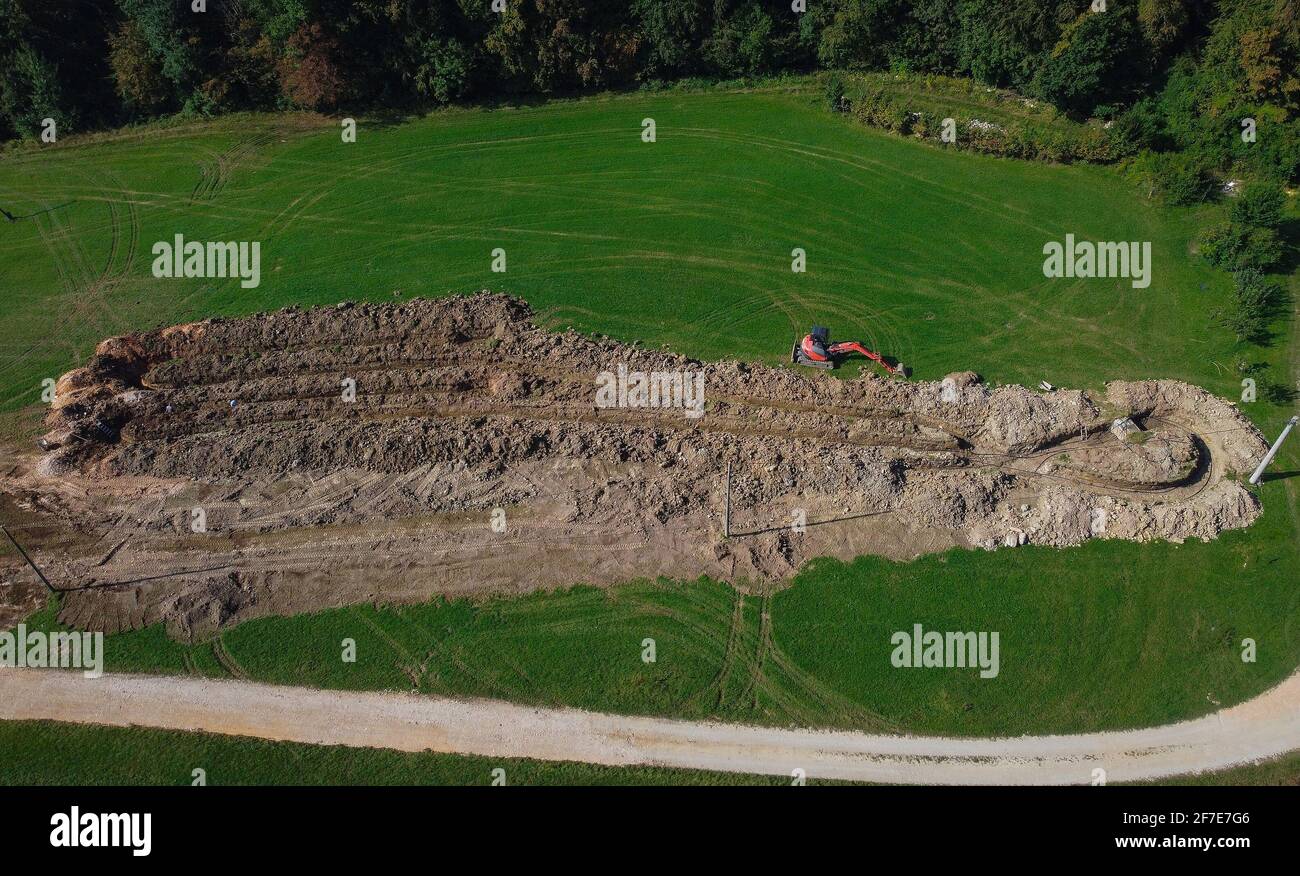 Vista aerea del drone del pozzo o trincea del collettore di riscaldamento geotermico nel terreno. Scavo di fossati o buchi per scambiatore di calore termico per una casa. OU Foto Stock