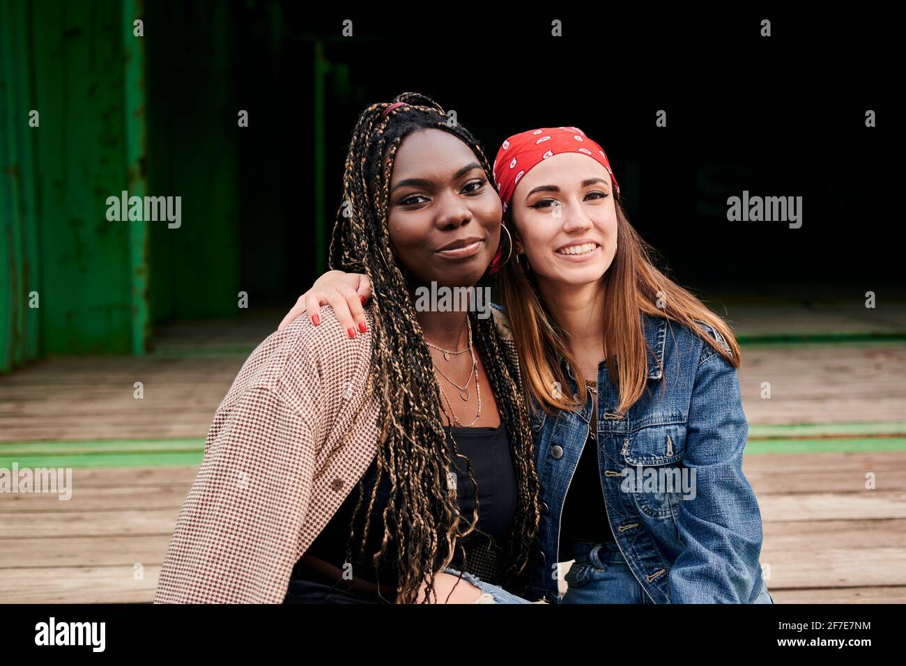 Ritratto di due giovani donne multietniche in abiti urbani sorridenti Foto Stock