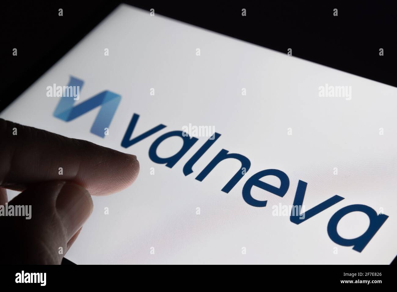 Concetto di vaccino Valneva COVID-19. Dito che punta verso il logo della società Valneva sullo sfondo sfocato. Stafford, Regno Unito, 6 aprile 2021. Foto Stock