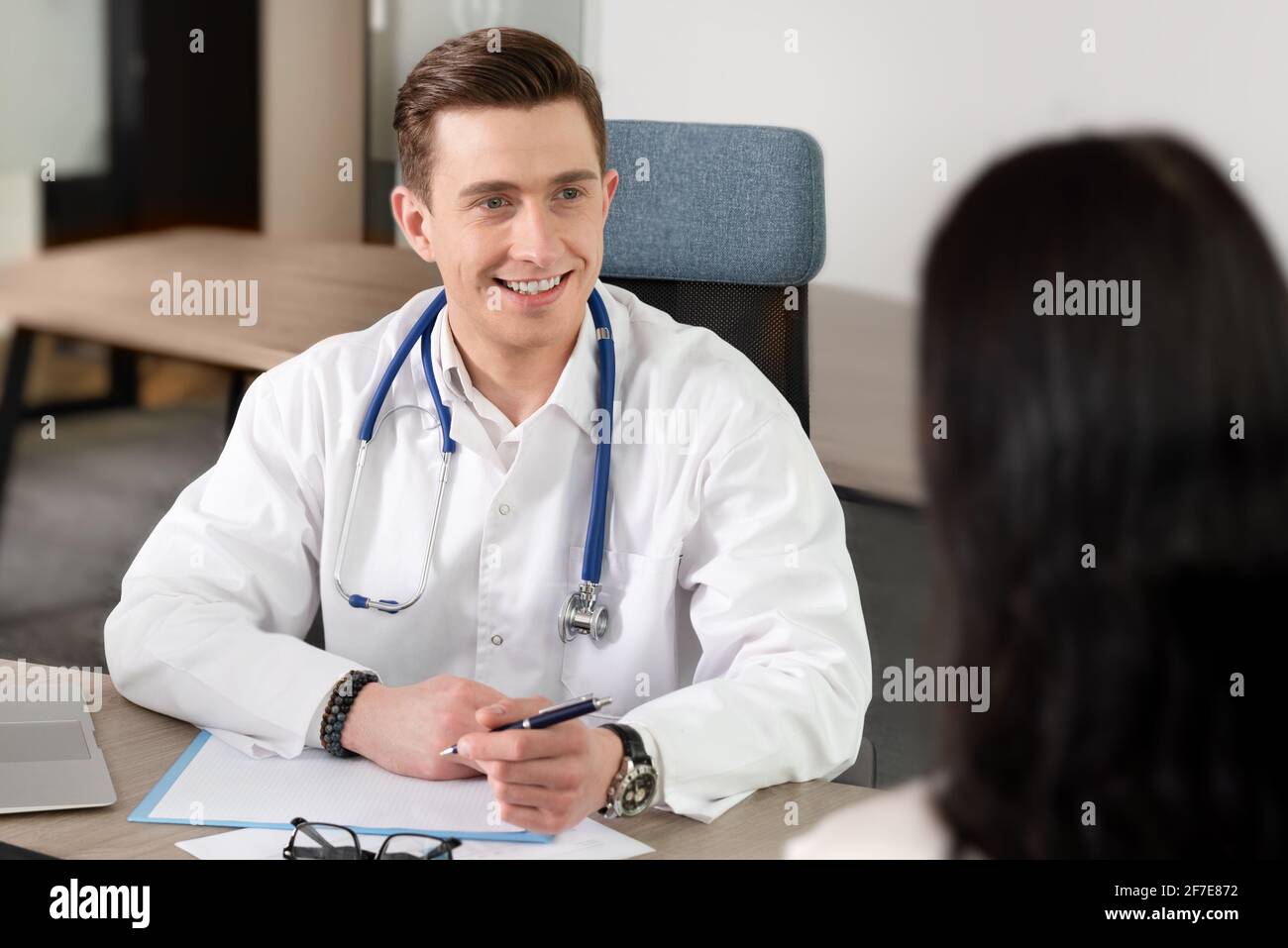 Consultazione medica. Sorridente medico e paziente in ufficio Foto Stock