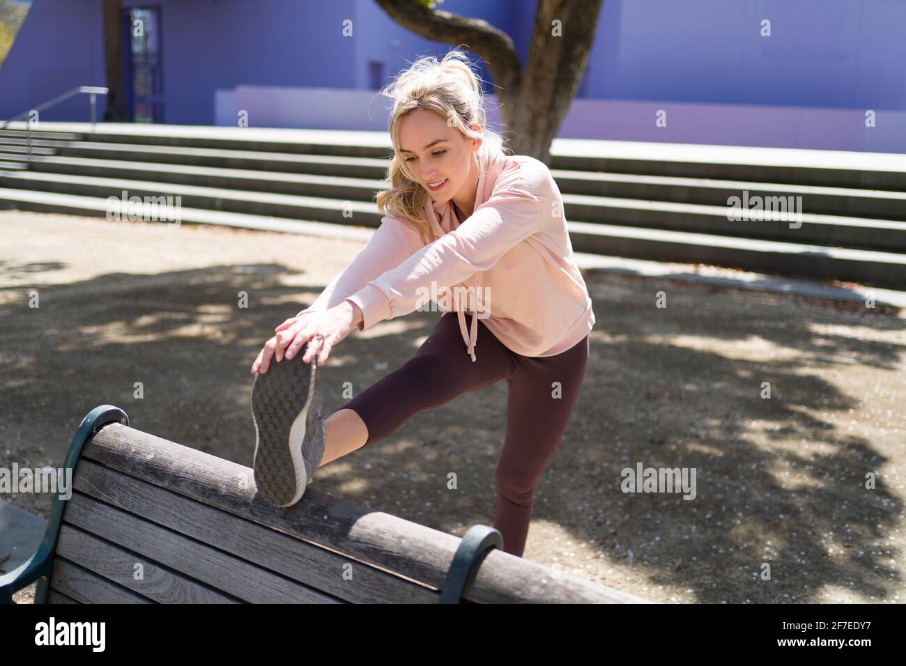 Giovane donna stretching prima di correre nel Parco Foto Stock