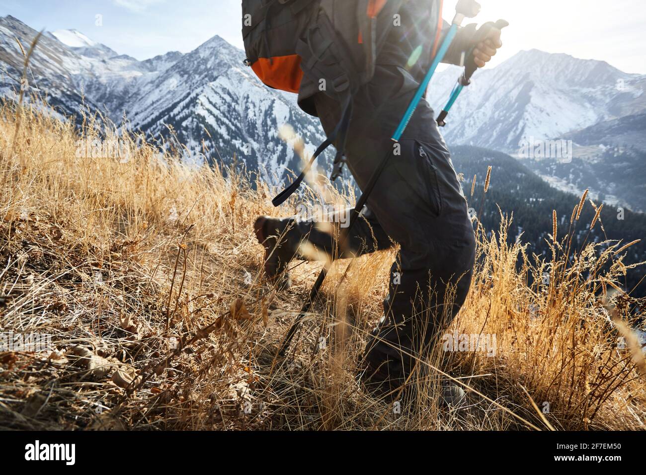 L'uomo turistico con zaino è a piedi nella valle di montagna autunno con cime innevate in Almaty, Kazakistan Foto Stock