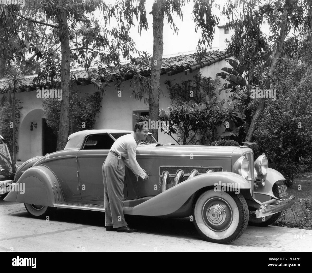 CLARK GABLE nel 1936 circa con il suo modello Duesenberg 1935 J9 Convertible Coupe Car Pubblicita per Metro Goldwyn Mayer Foto stock Alamy