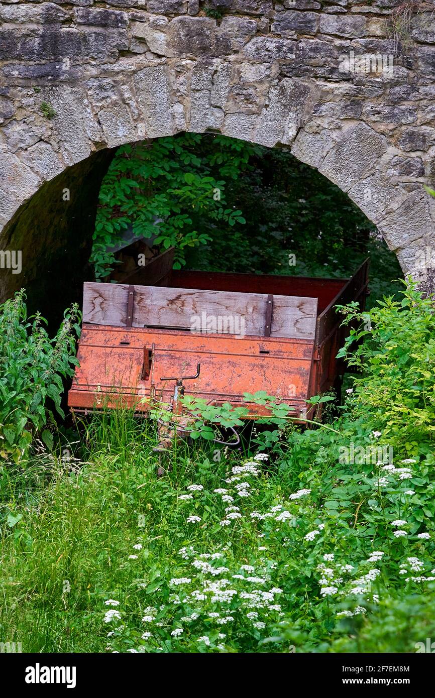 Un vecchio carro di rifiuti arrugginito, utilizzato per feci umane parcheggiate sotto il ponte che conduce al castello Burgruine Leofels. Foto Stock
