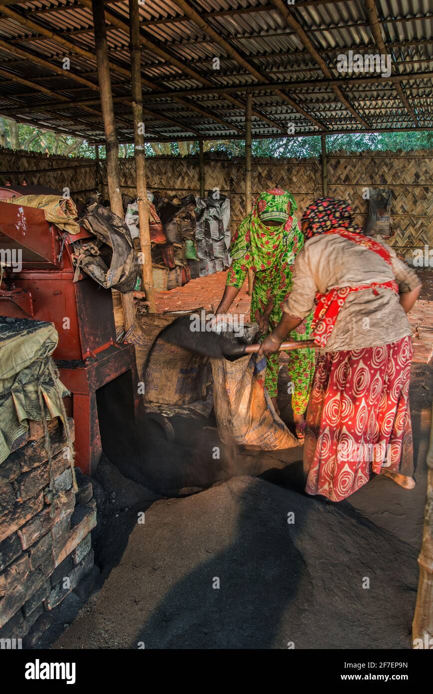 Un lavoro femminile lavora sul carbone in un campo di mattoni a Khulna, Bangladesh. Foto Stock