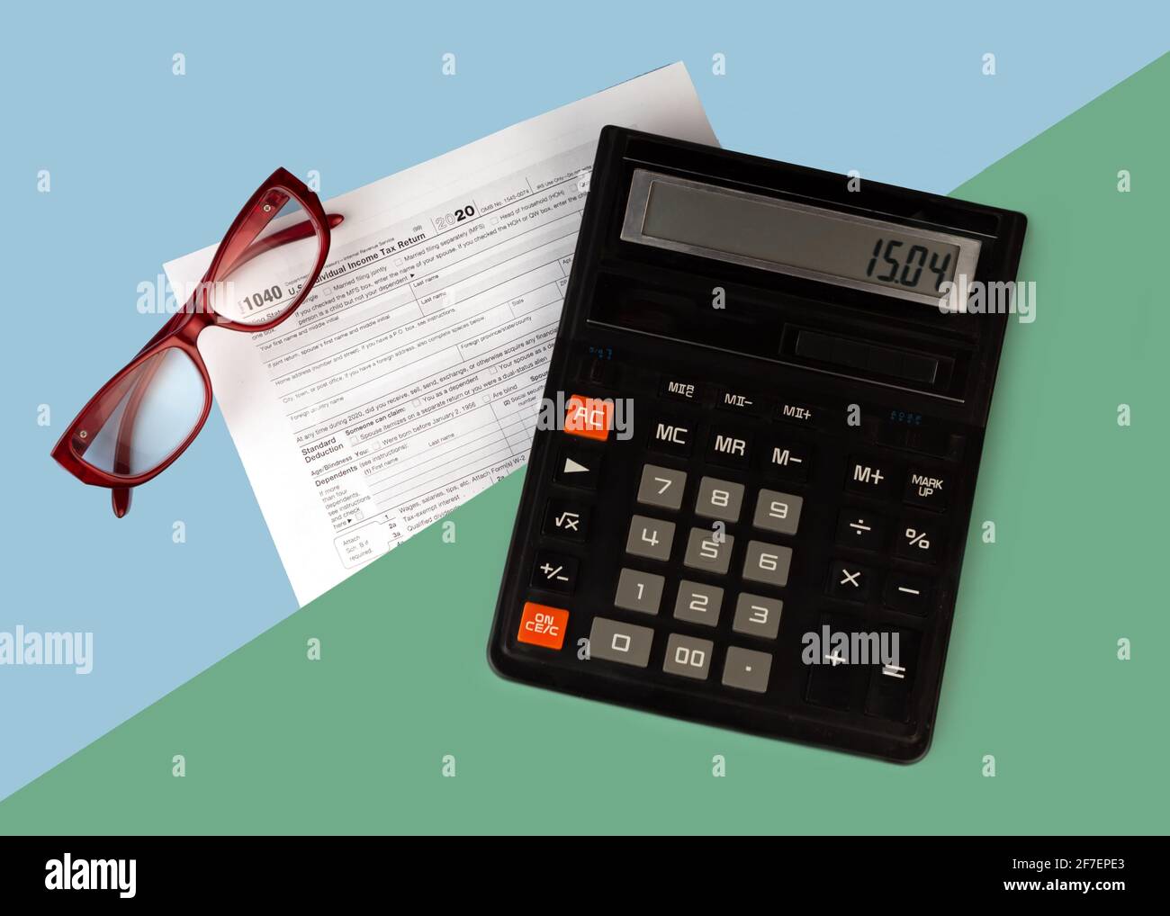 Concetto di giorno fiscale. Calcolatrice e foglio di carta con modulo fiscale degli Stati Uniti 1040. Pagare le tasse in nuovi anni. Copia spazio. Foto Stock