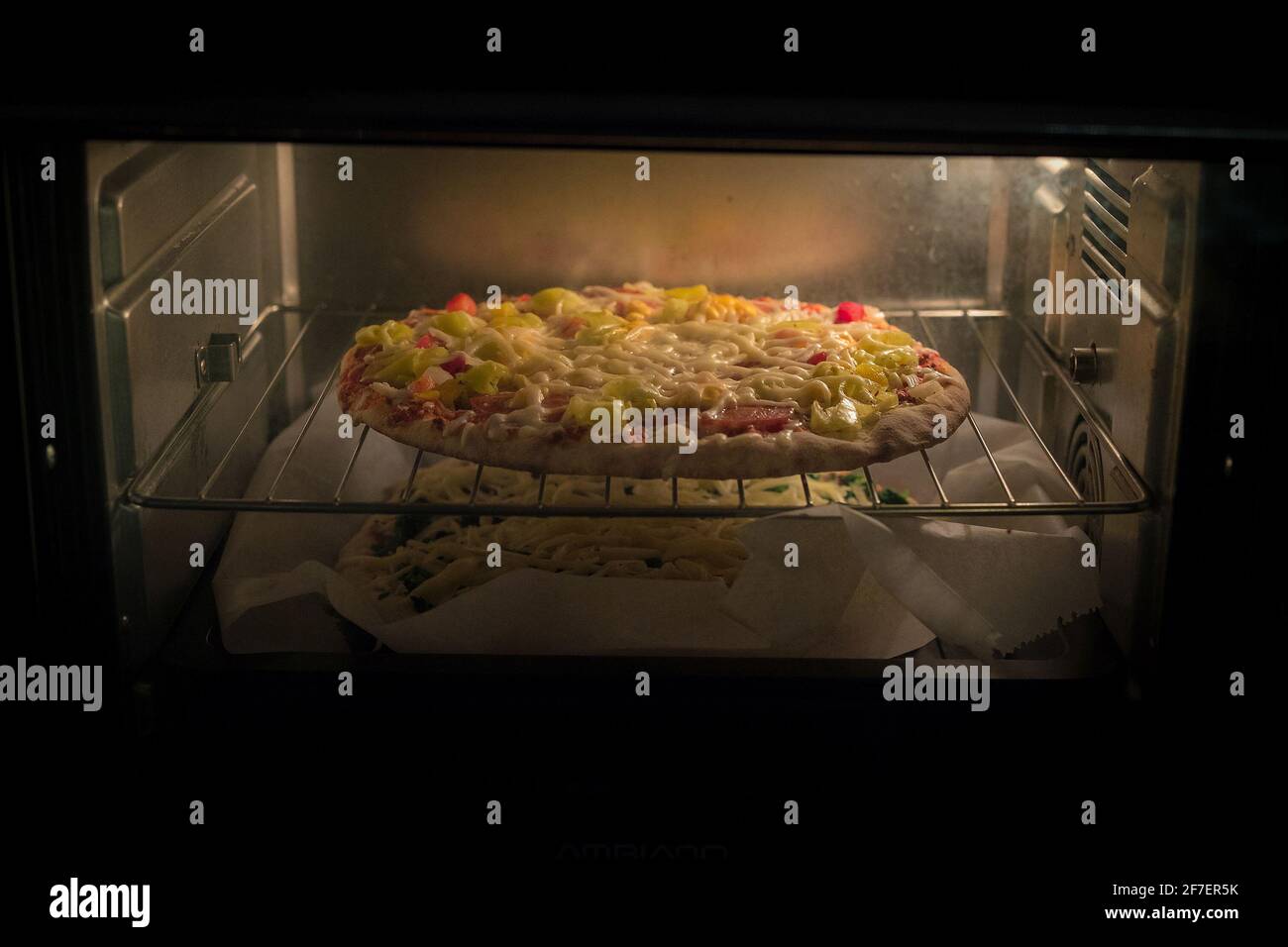 La pizza surgelata di un supermercato o di un negozio è vista in un forno  elettrico caldo. Due pizze al supermercato che si cuocono una sopra l'altra  Foto stock - Alamy