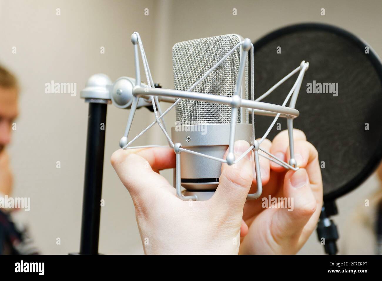 Le mani maschili regolano il microfono professionale per la registrazione del suono. Foto Stock