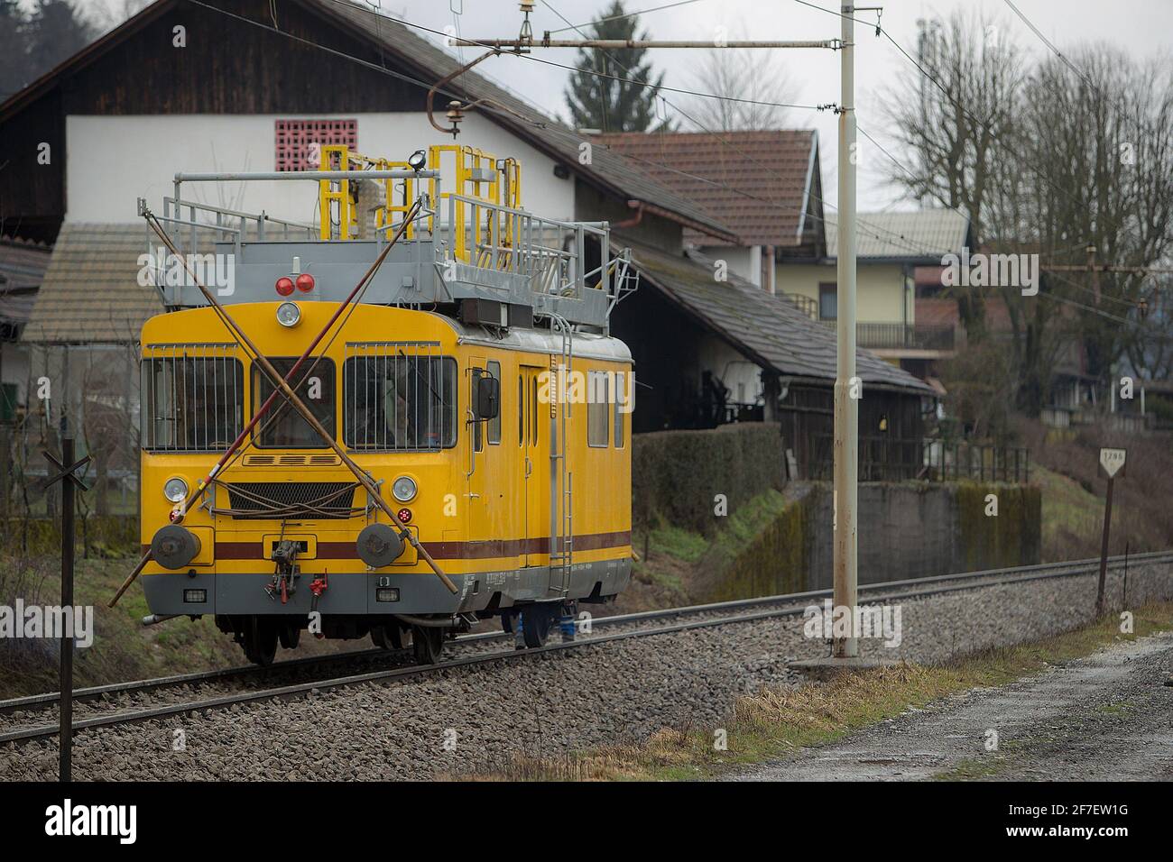 Macchine per la costruzione di ferrovie - una draisina gialla di manutenzione della catenaria è in piedi su un binario aperto. Foto Stock