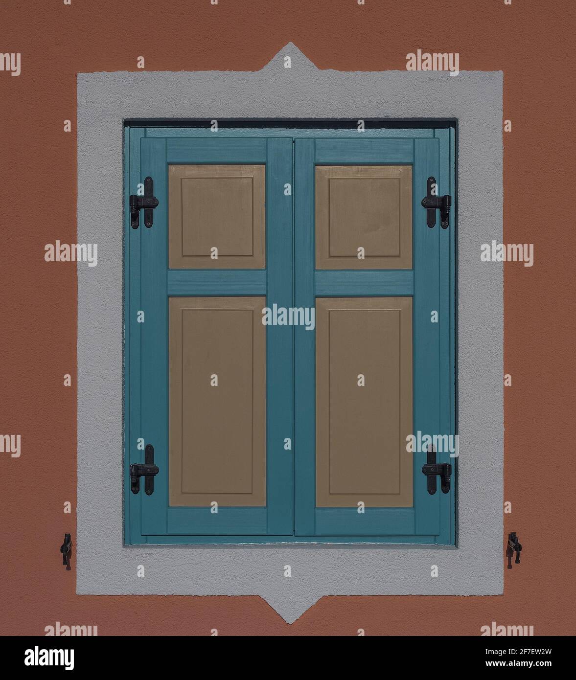 Bella finestra pannello in tourchoise colore con insets giallo e cornice bianca su una facciata arancione. Bella finestra su un display. Foto Stock