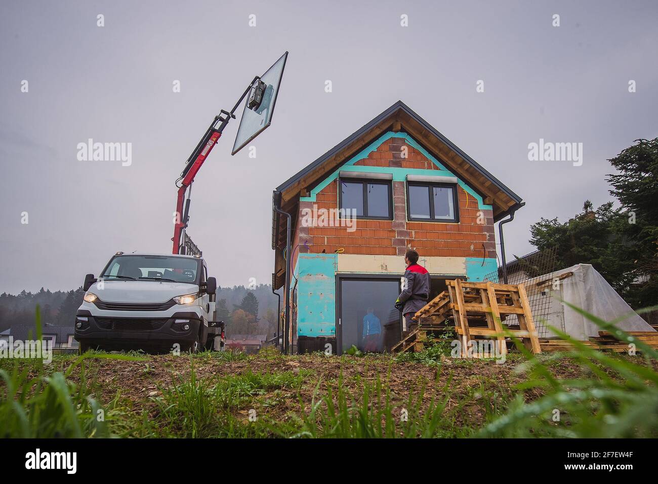 Foto di installazione in vita reale senza scale di finestre o porte panoramiche utilizzando un ascensore hidraulic o un ascensore su un camion. Autocarro che solleva un vetro vento Foto Stock