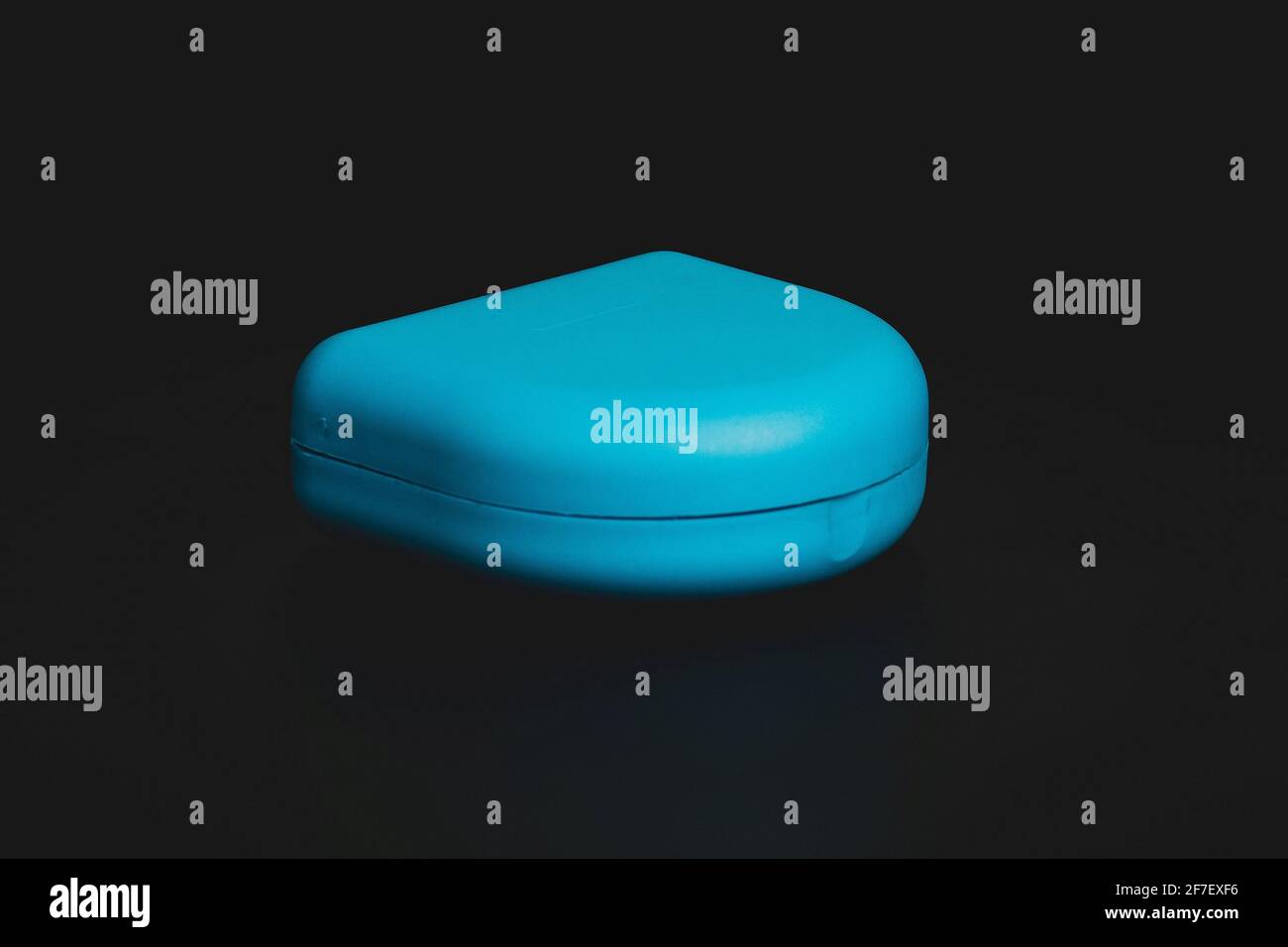 Custodia blu per fermo ortodontico realizzata in plastica trasparente isolata in nero. Fermo per l'allineamento dei denti. Foto Stock