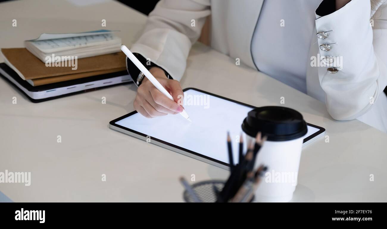 Chiudi uo businesswoman tiene la penna stilo disegno su tablet digitale sul posto di lavoro Foto Stock