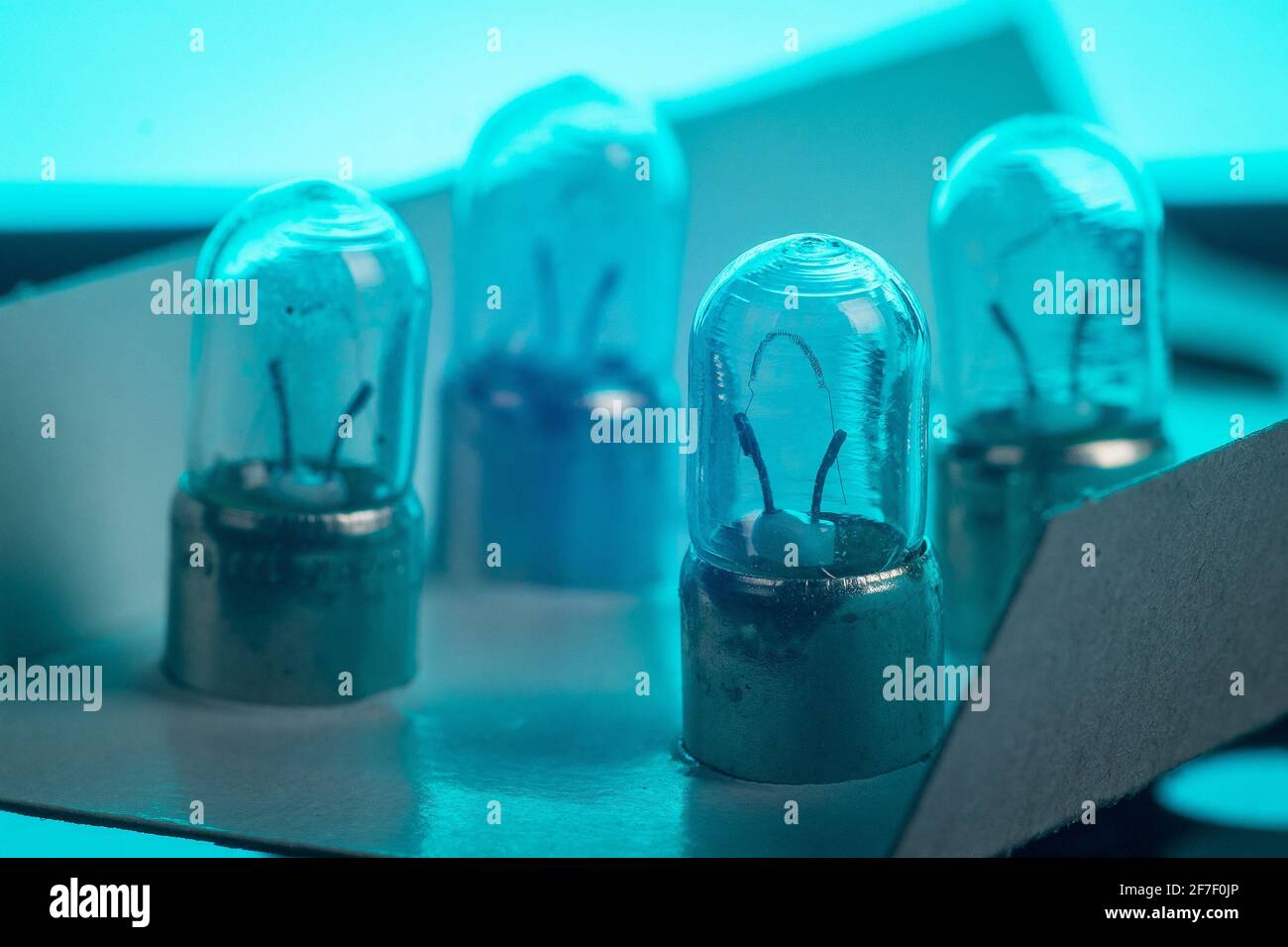 Dettaglio della lampadina della luce di posizione di un'auto di tipo più vecchio. Moltissime lampadine di posizione in un imballaggio di cartone sfuso. Foto Stock