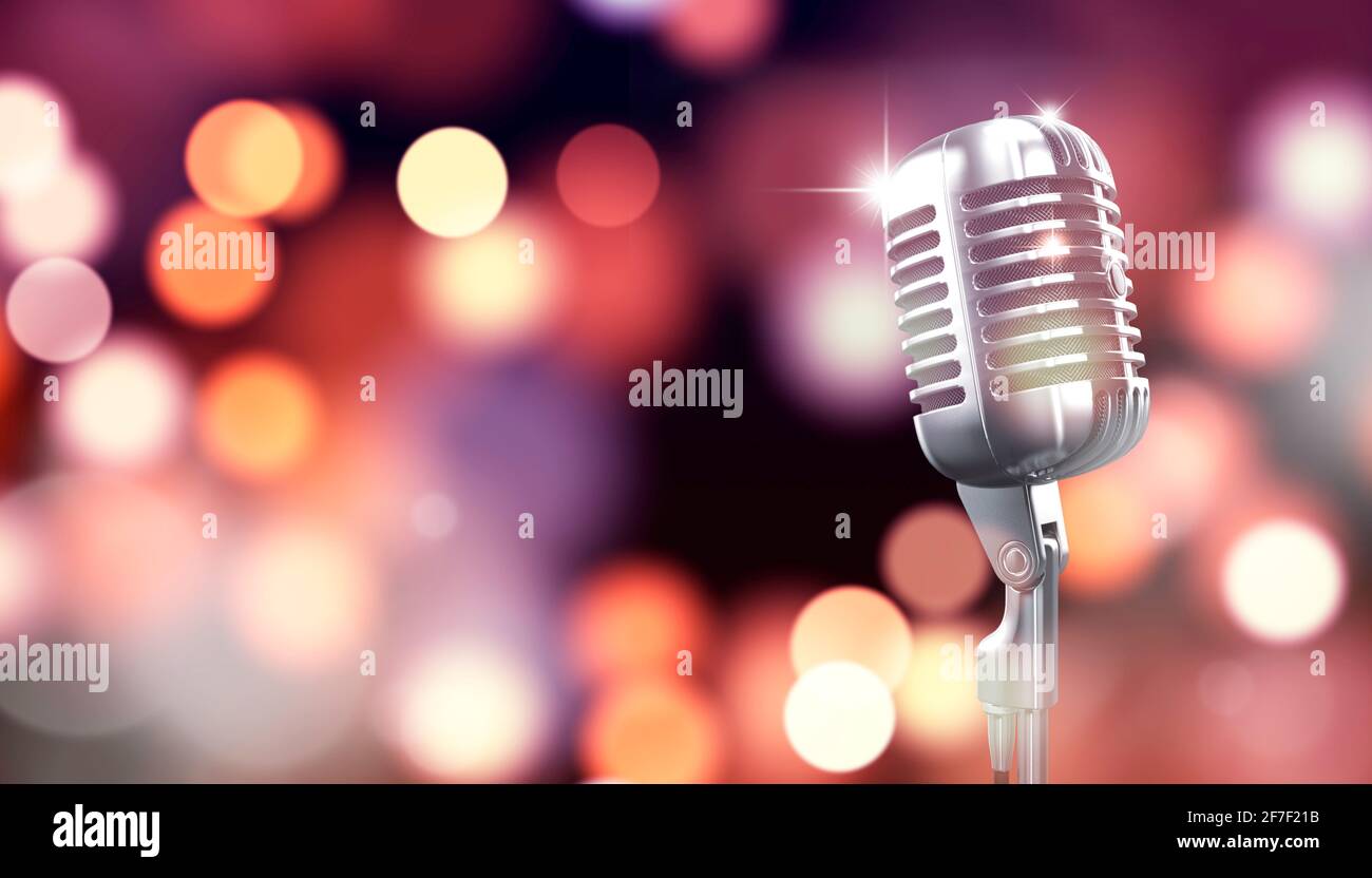 Microfono retrò sul palco con sfondo luminoso bokeh. Foto Stock