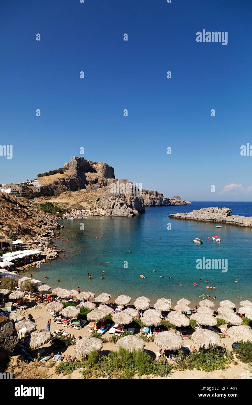 L'Acropoli di Lindian si affaccia sulla baia di San Paolo a Lindos, a Rodi, in Grecia. L'antico monumento si erge sotto un cielo azzurro limpido. Foto Stock