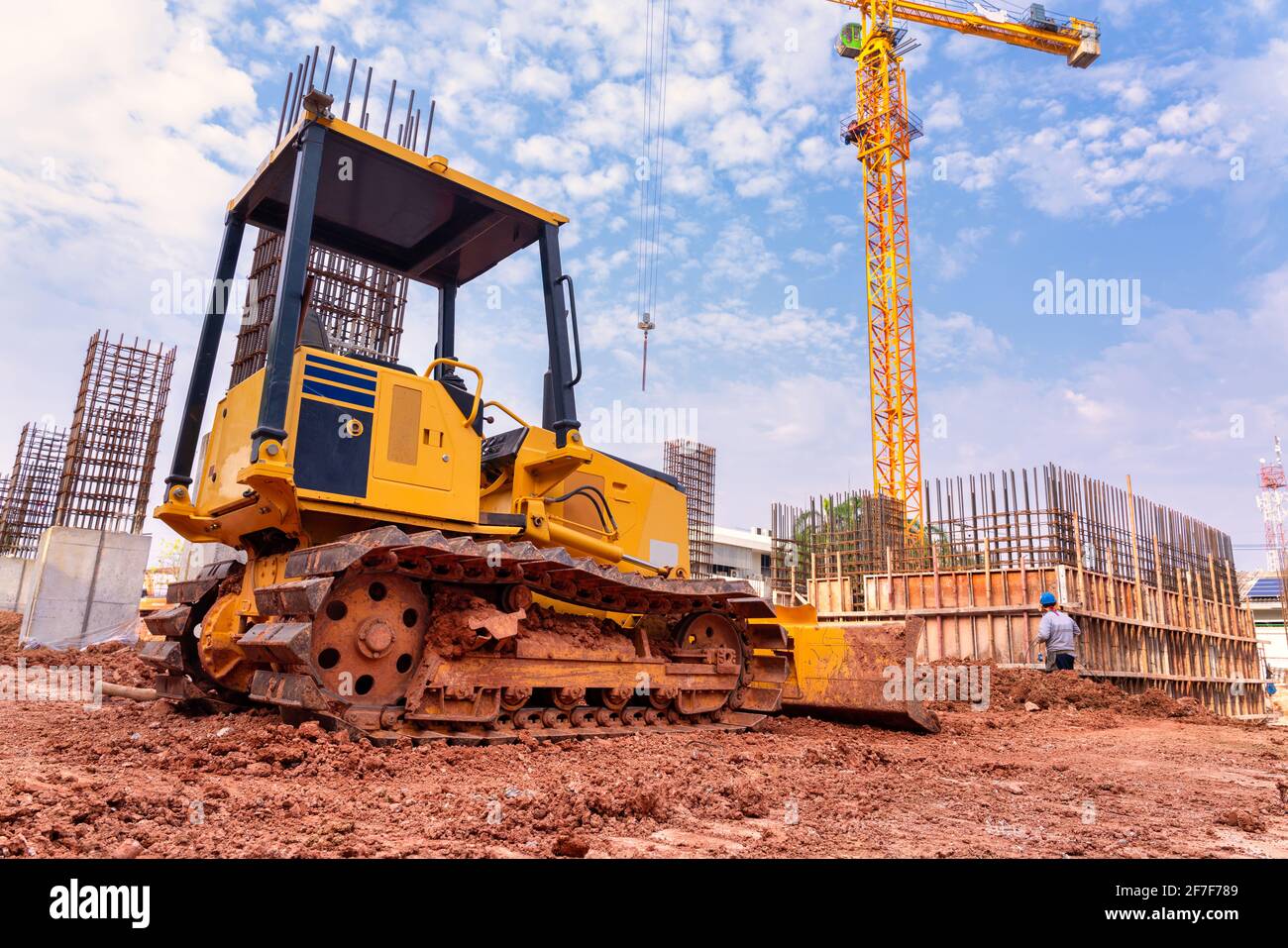 Escavatore per lavorare con terra e sabbia in sandpit in lavori di fondazione dell'edificio in cantiere Foto Stock