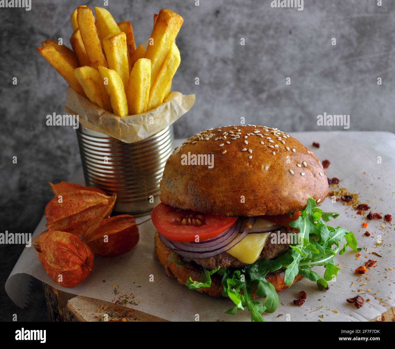 Hamburger e hamburger fatti in casa con verdure fresche e formaggio. Patate, spezie ed elementi decorativi. Foto Stock