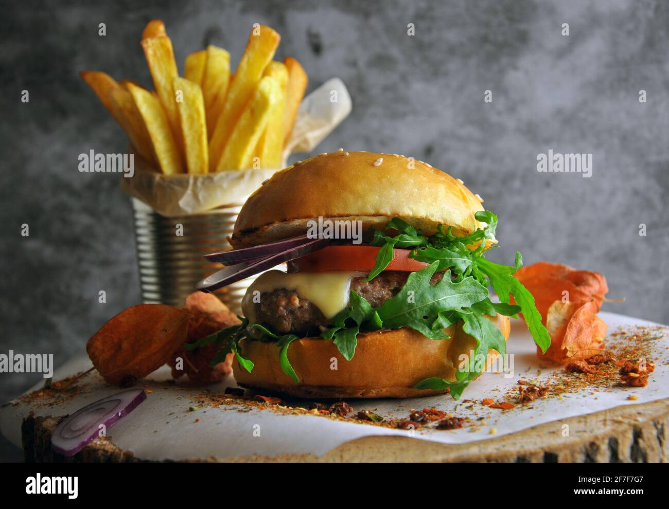 Hamburger con rucola e salsa maionese servito su tavola di legno Foto Stock