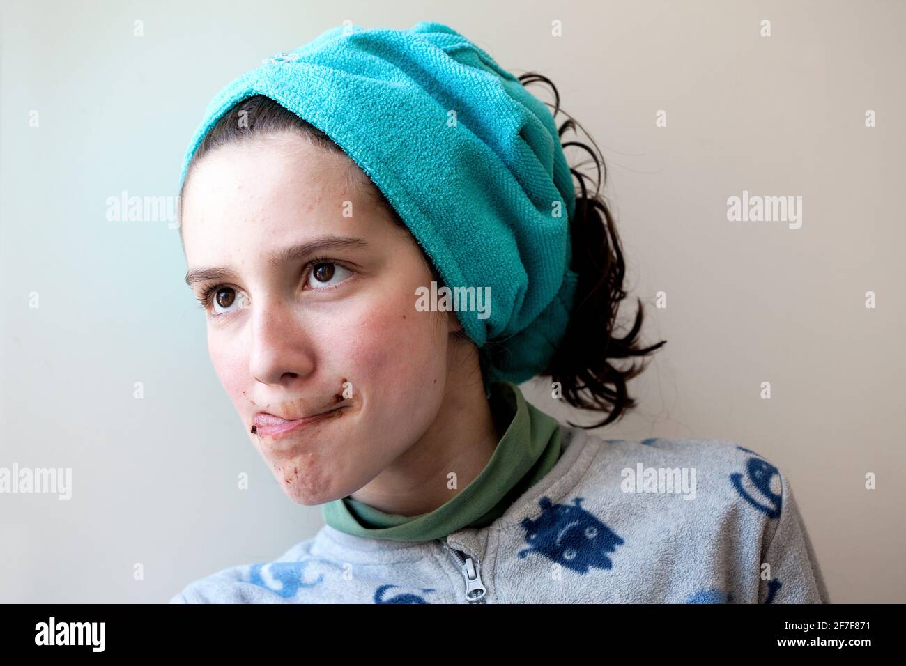 ragazzo di 12 anni che lecca il cioccolato dal labbro superiore Foto Stock