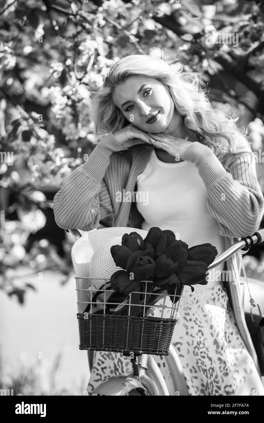 Escursioni in bicicletta. Donna in bicicletta d'epoca. Ragazza romantica e fiore sakura. Stagione primaverile. Fioritura dell'albero di ciliegio. Sperimentate la cultura mentre lo avate Foto Stock