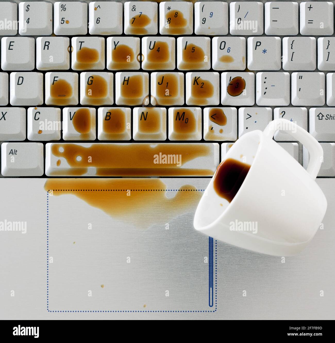 Caffè versato sulla tastiera del notebook del computer primo piano Foto Stock