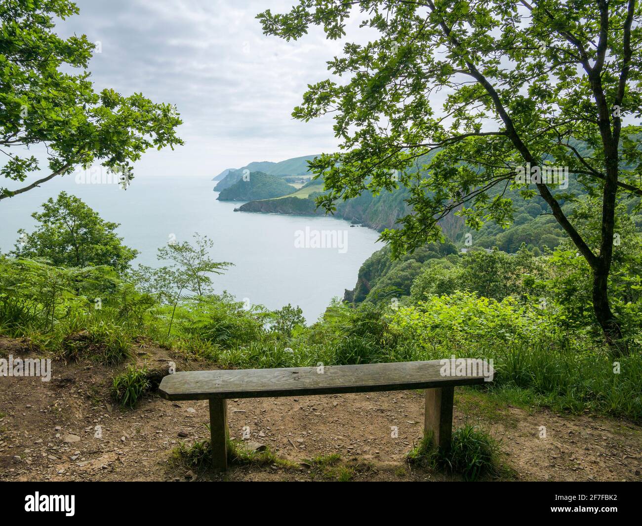 La vista su Woody Bay a Valley of the Rocks e Foreland Point dal South West Coast Path a West Woodybay Woods nel Parco Nazionale di Exmoor, North Devon, Inghilterra. Foto Stock