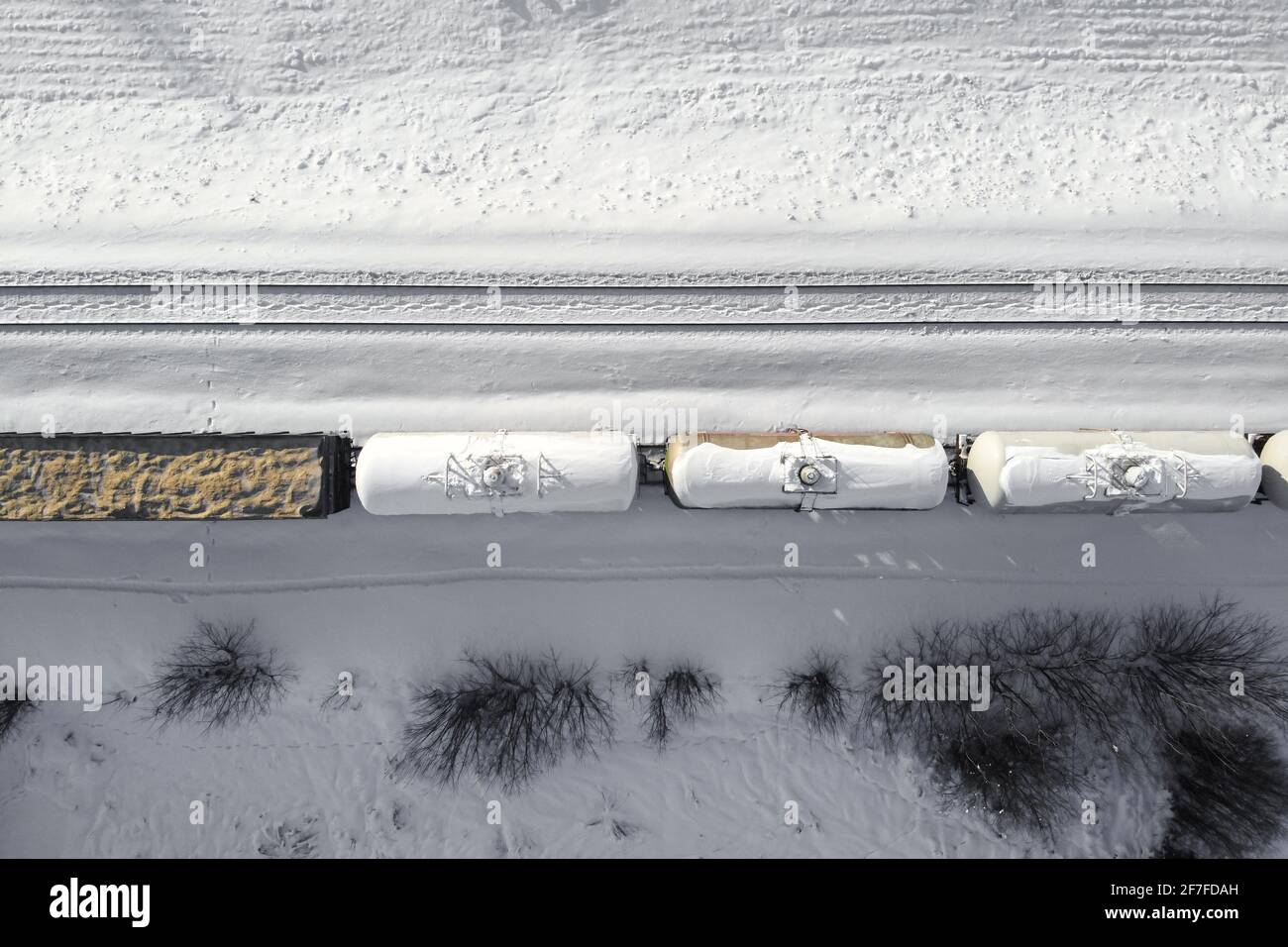 Vista aerea dei carri cisterna dei treni di carico, una ferrovia a doppio binario. Ferrovia invernale con neve bianca, vista dall'alto. Infrastrutture di trasporto, binario ferroviario, sno Foto Stock