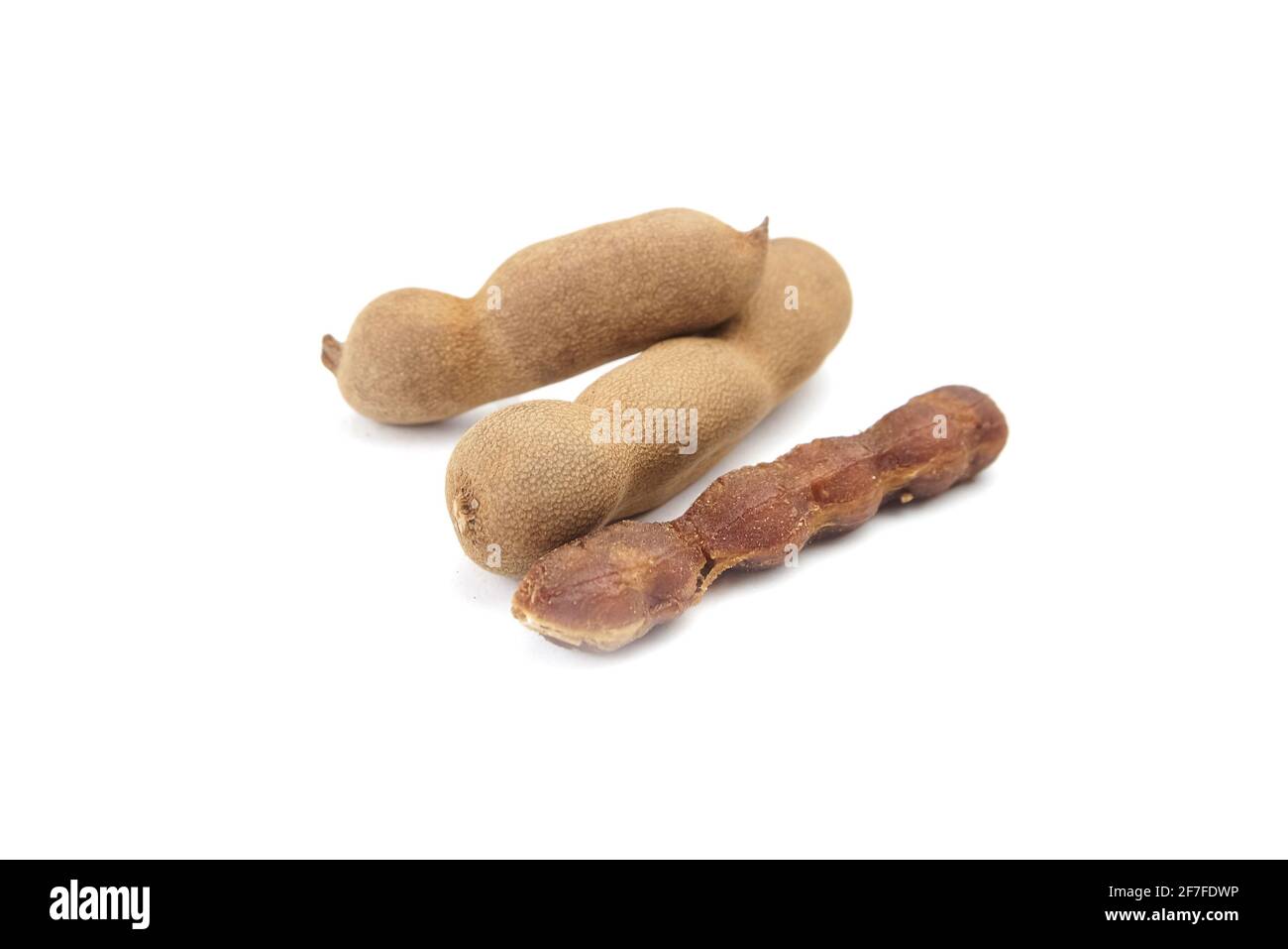 Tamarind frutta isolato su sfondo bianco. Gruppo di baccelli di tamarindo. Mucchio di frutta tropicale, data indiana Foto Stock