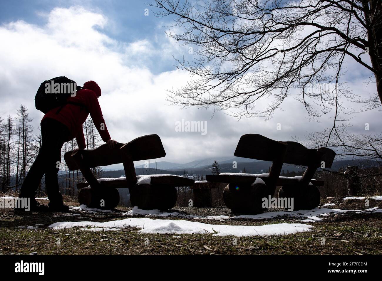 Bad Harzburg, Germania. 07 aprile 2021. Un escursionista con uno zaino si trova su una panchina vicino al Rabenklippen nel Parco Nazionale di Harz. Credit: Swen Pförtner/dpa/Alamy Live News Foto Stock