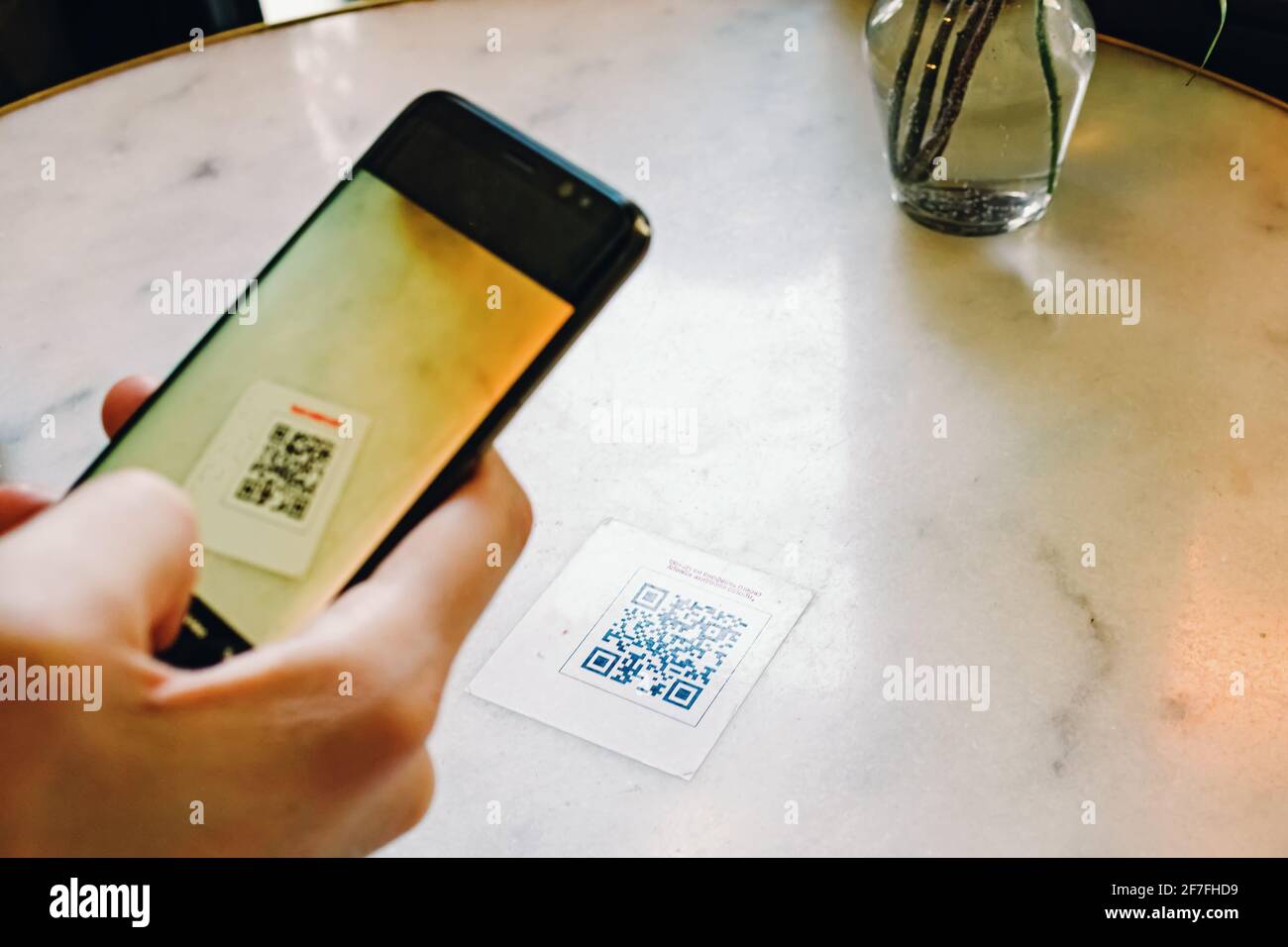Uomo che scansiona il codice QR con il cellulare al ristorante. Foto Stock