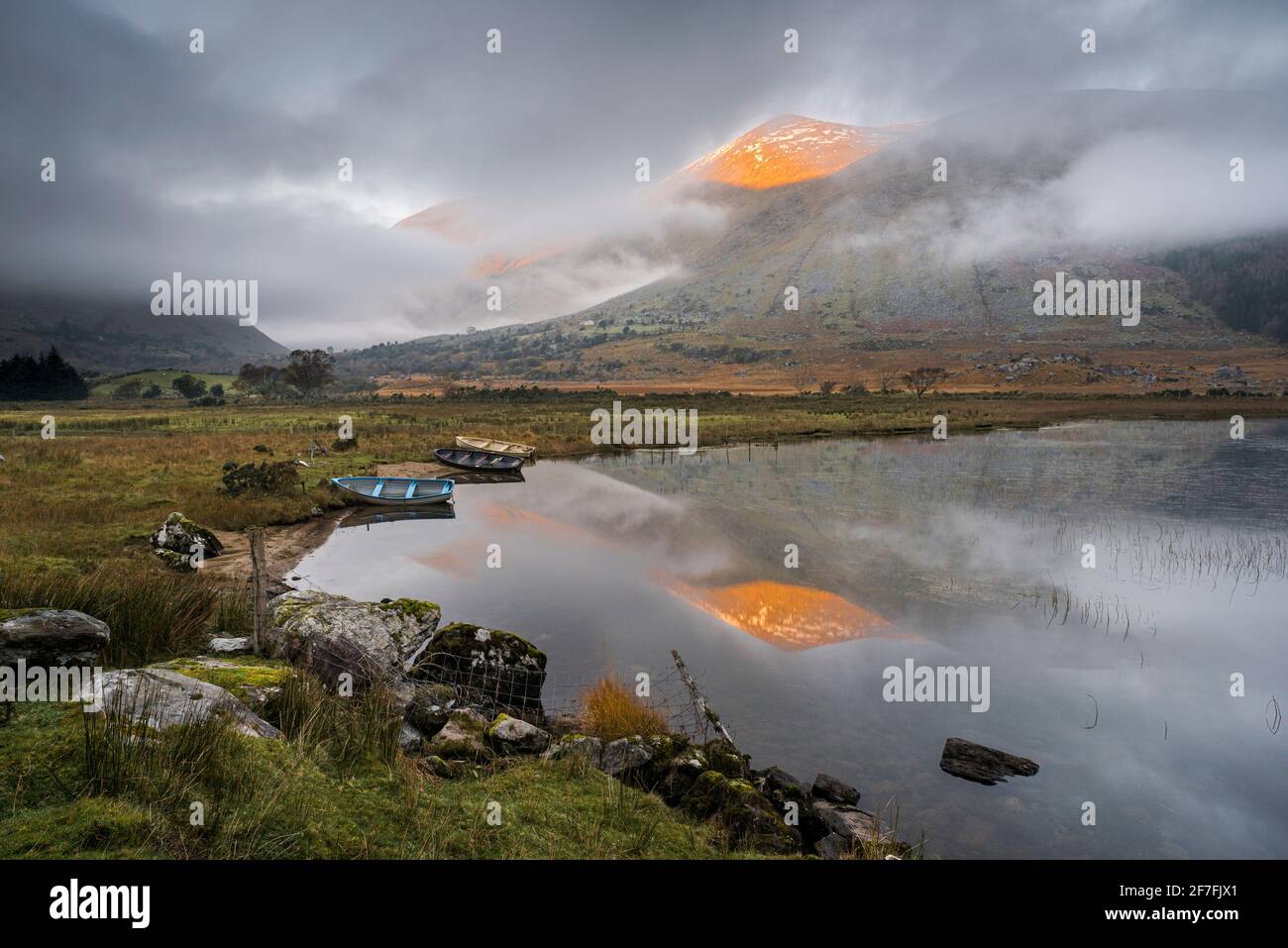 Macgillycudy's Reeks montagne riflesse in Lough Gummeenduff, luce del sole serale, Black Valley, Killarney, County Kerry, Munster, Repubblica d'Irlanda Foto Stock