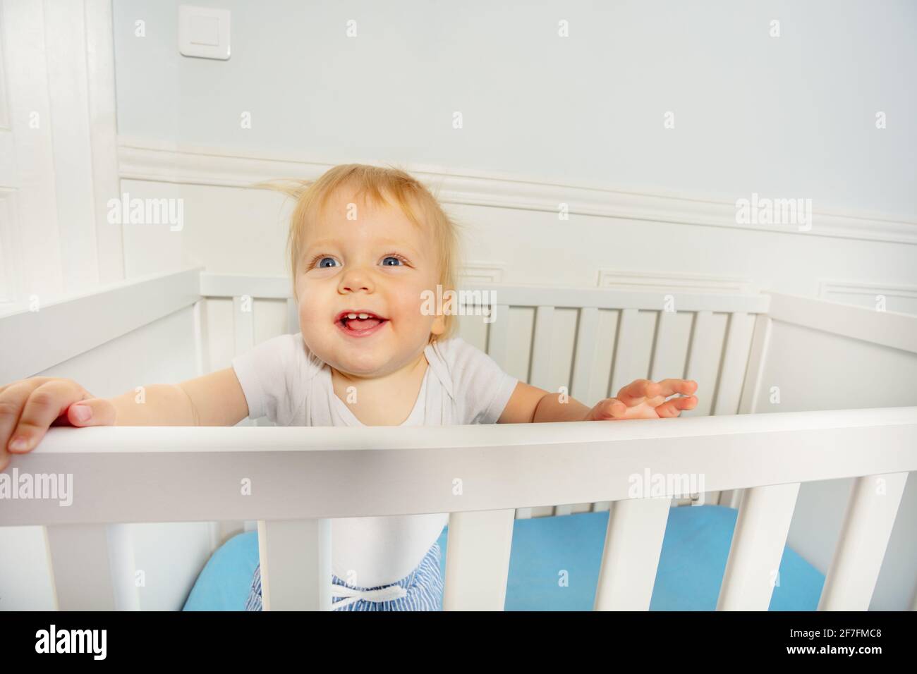 Il bambino si trova nel presepe con espressione felice Foto Stock