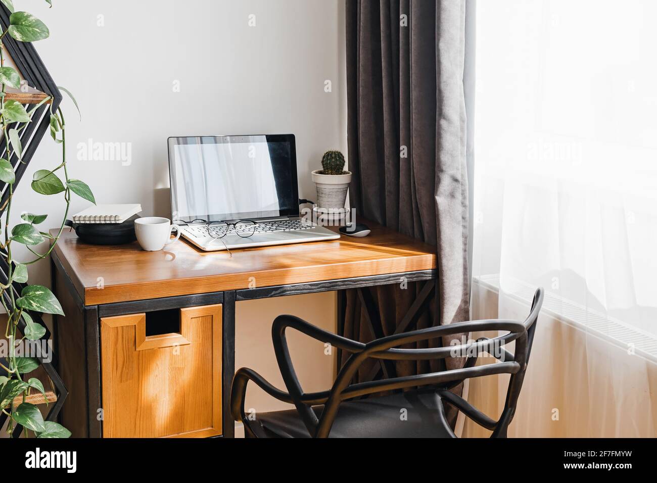 Ambiente di lavoro moderno a casa con computer portatile su tavolo di legno Foto Stock