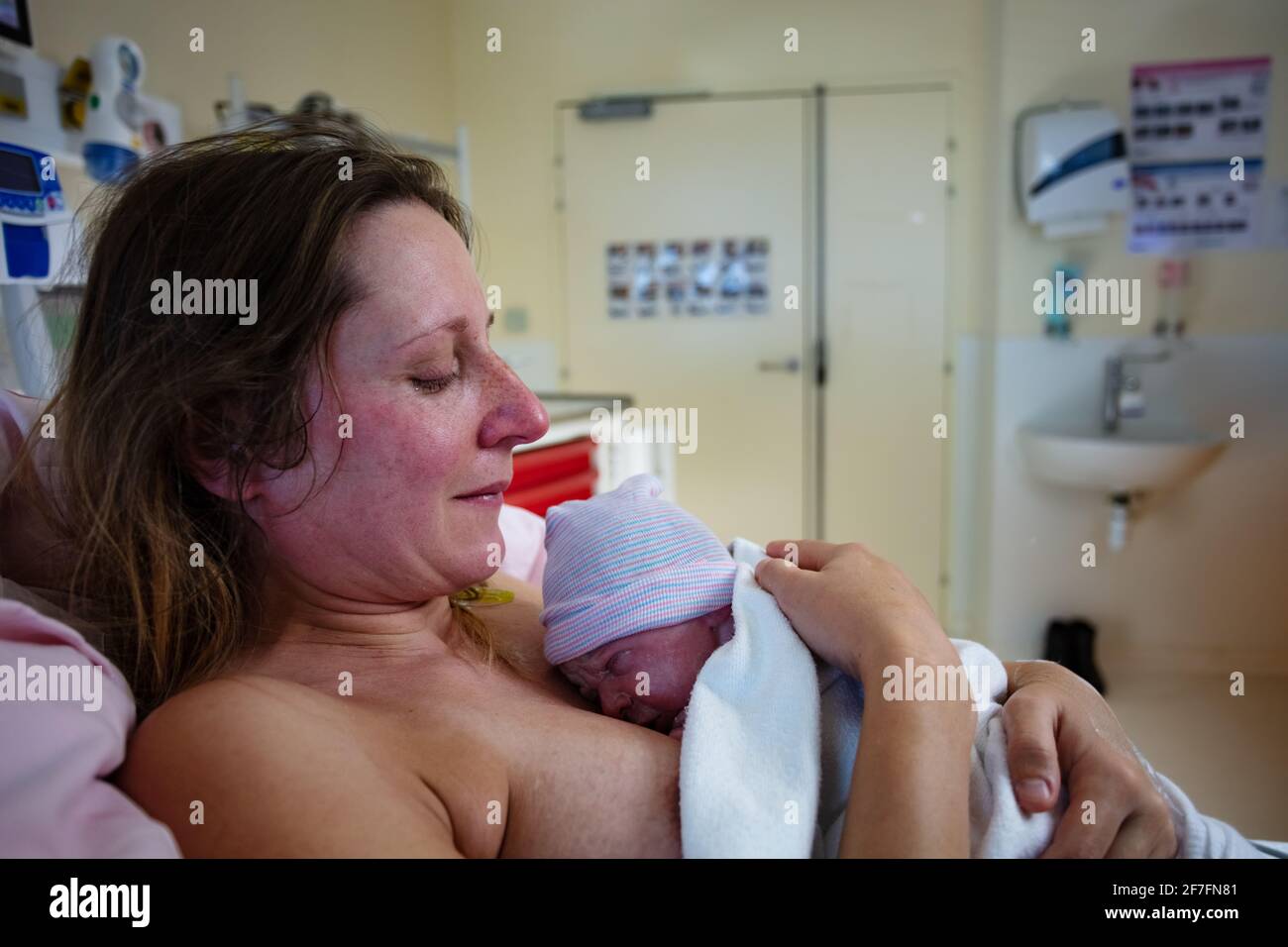 La donna tiene il bambino neonato dopo il parto Foto Stock