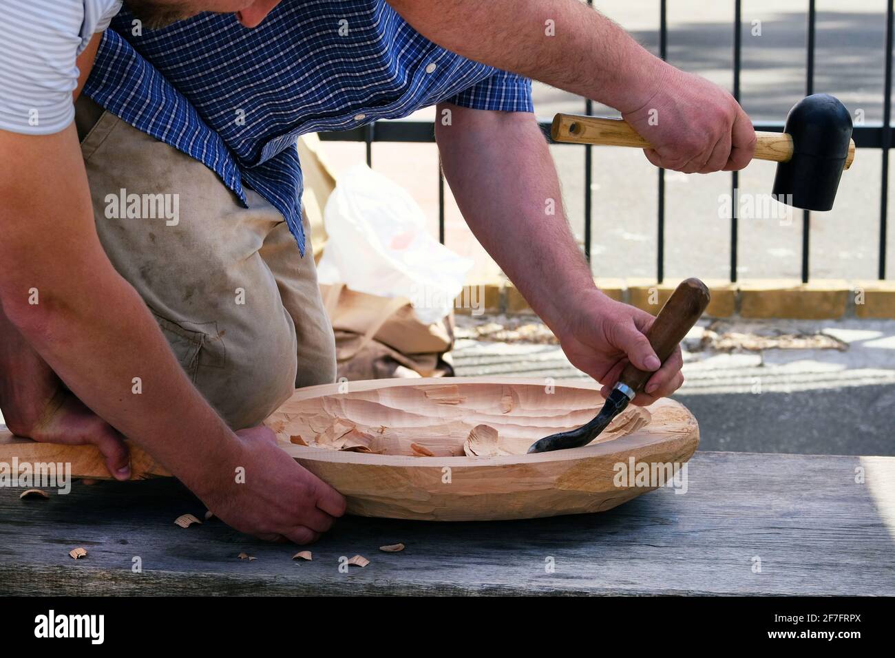 Scultura in legno. Due falegnami professionisti travano il prodotto in legno con un utensile per la lavorazione del legno, le mani si avvicinano. Concetto di carpenteria e artigianato. Foto Stock