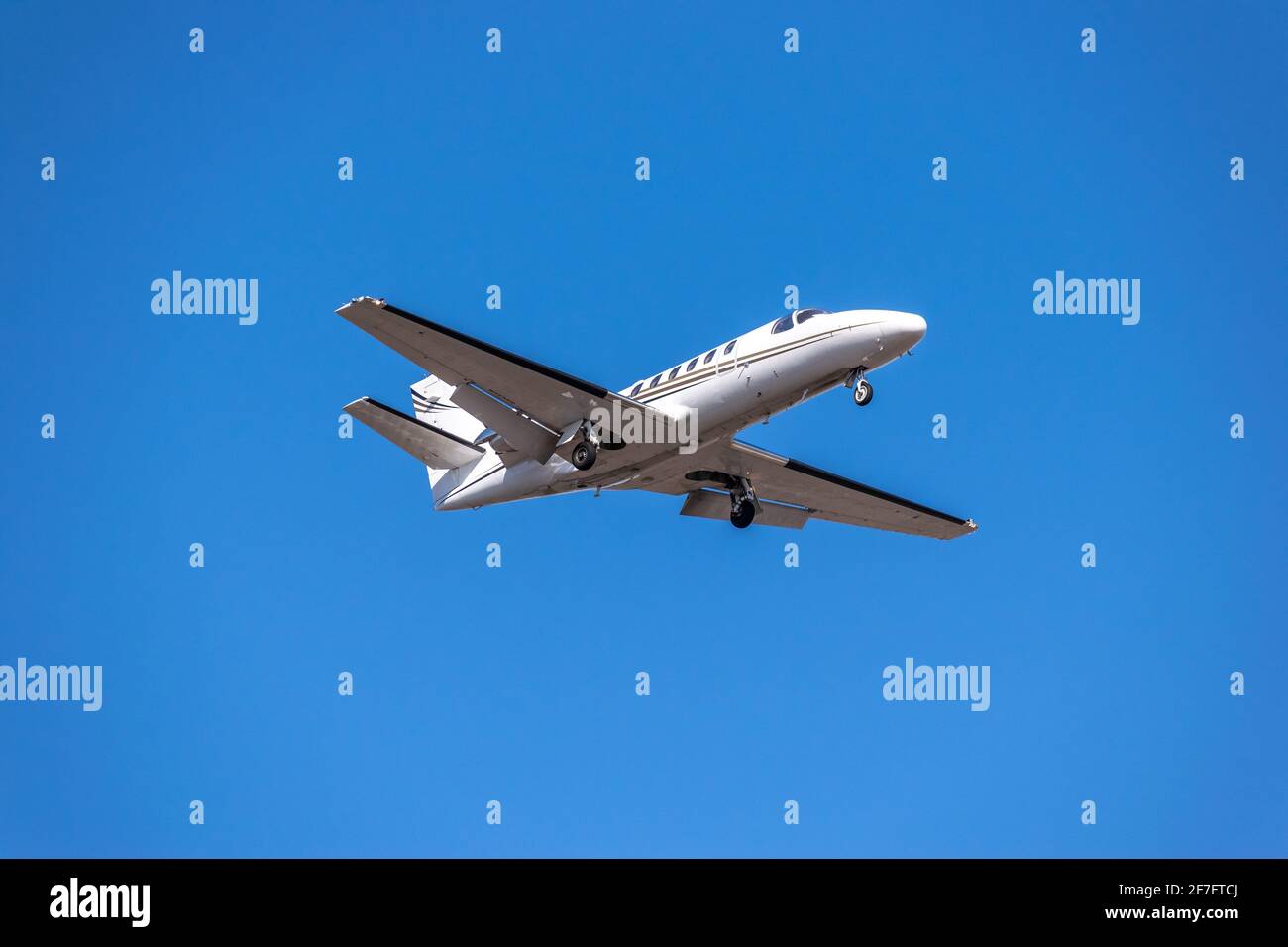 Business jet atterraggio in cielo blu Foto Stock