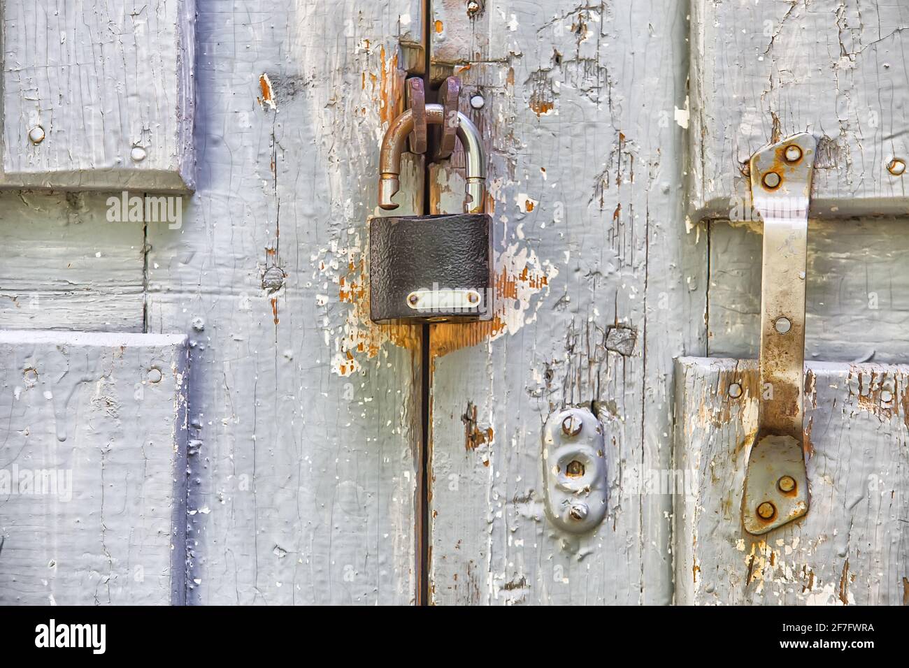 vecchia porta in legno colorato con lucchetto e maniglia Foto Stock