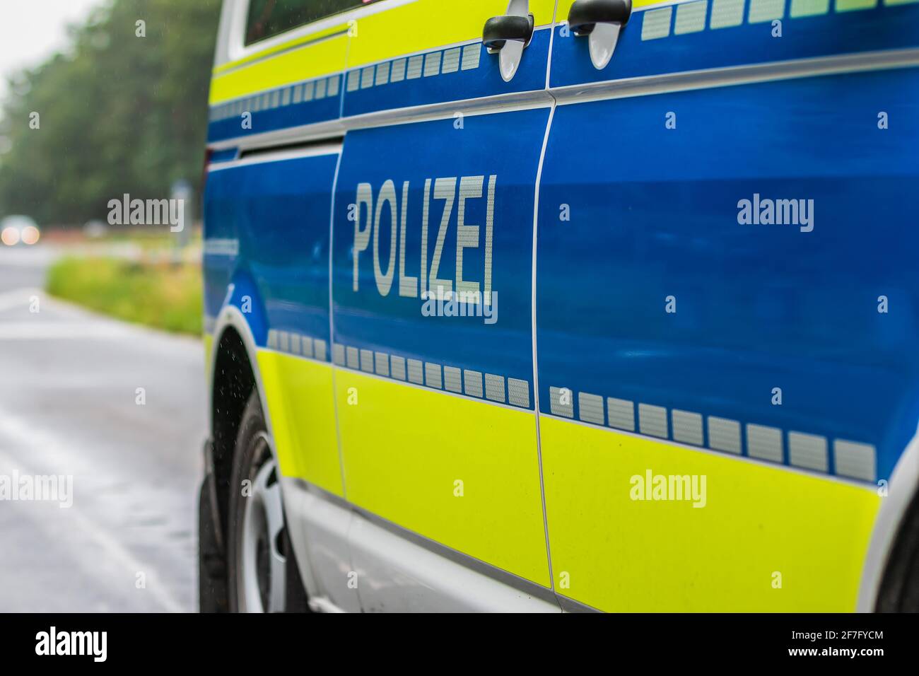 Vista laterale di un'auto della polizia tedesca. Scritta della polizia sulla carrozzeria dal lato passeggero. Sfondo blu e colore giallo con strisce riflettenti. Alta Foto Stock