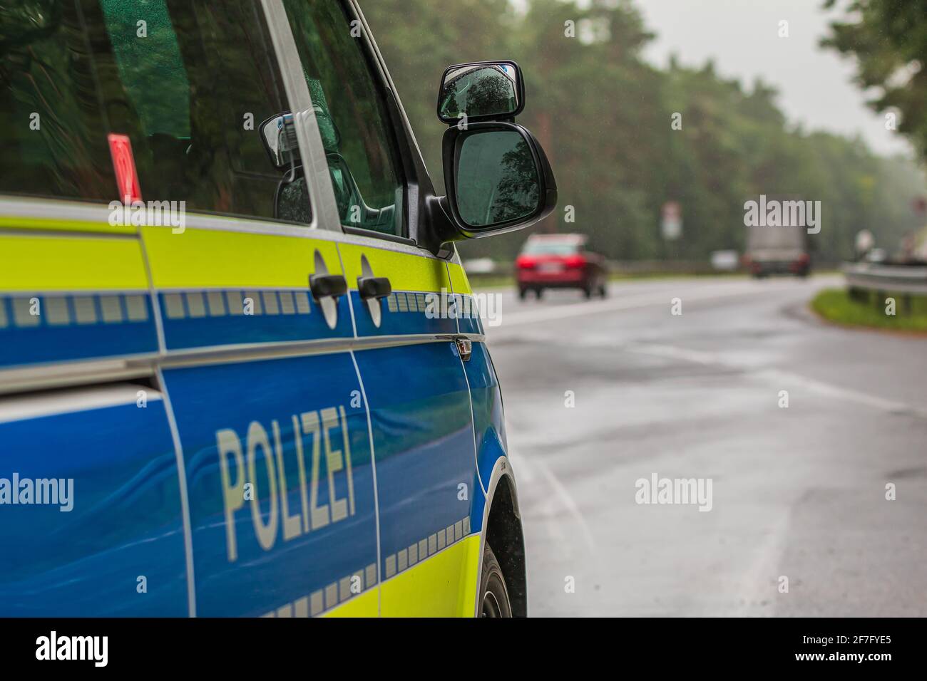 Macchina di polizia dal lato. Lato passeggero con scritta della polizia sul corpo. Autostrada sullo sfondo. Specchietto del vetro dal lato passeggero con Foto Stock Macchina di polizia dal lato. Lato passeggero con scritta della polizia sul corpo. Autostrada sullo sfondo. Specchietto del vetro dal lato passeggero con Foto Stock