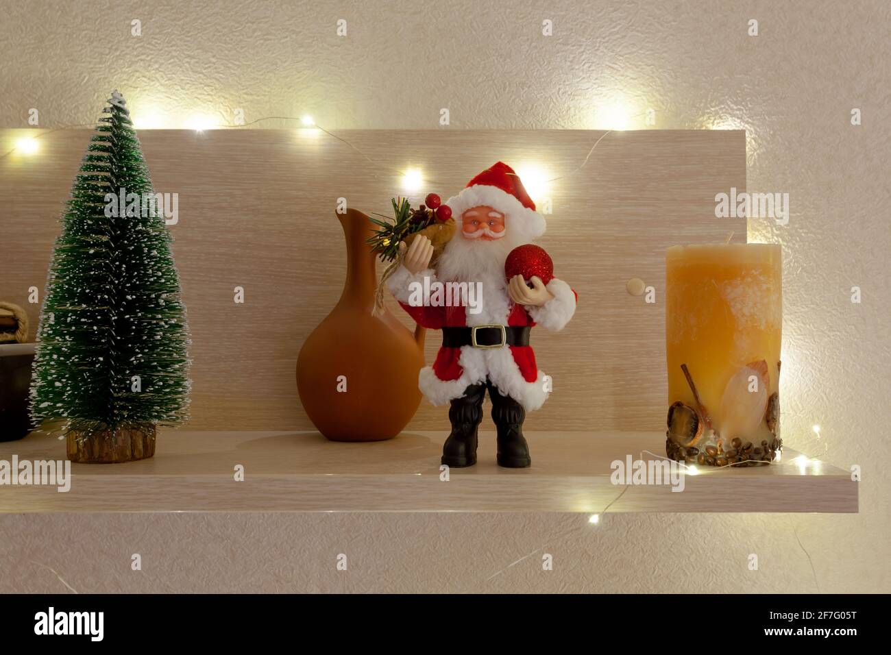 Babbo Natale e un piccolo albero di Natale su un legno ripiano Foto Stock