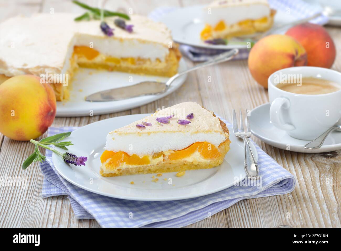 Deliziosa crostata di pesca con miele di lavanda e meringa dolce servita su un tavolo di legno con una tazza di caffè crema Foto Stock