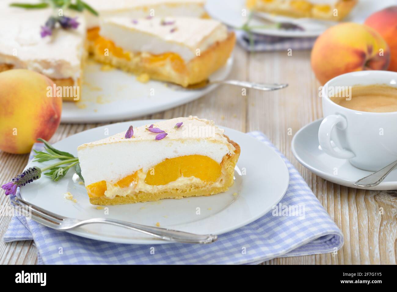 Deliziosa crostata di pesca con miele di lavanda e meringa dolce servita su un tavolo di legno con una tazza di caffè crema Foto Stock