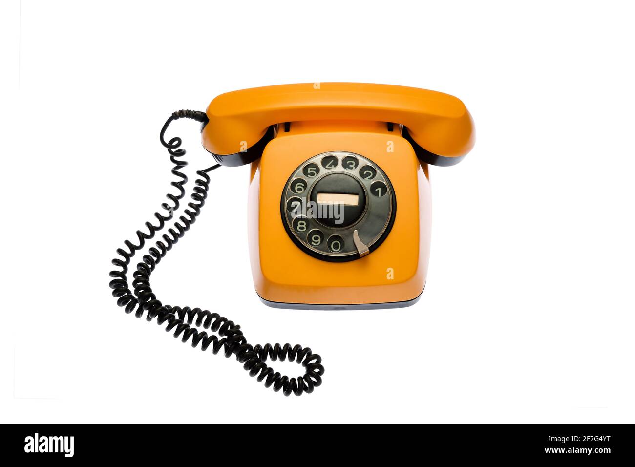 Vecchio telefono con linea rotante arancione, isolato su sfondo bianco. Foto Stock