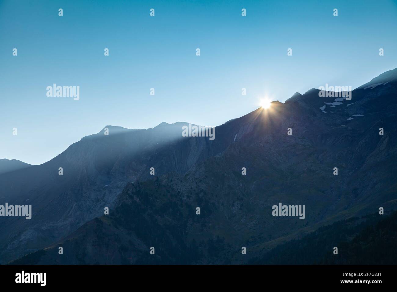 Prima luce d'alba e il sole sulle montagne solitarie d'estate, sotto un cielo azzurro pulito e enorme, Pirenei aragonesi, provincia de Huesca, Poset Foto Stock