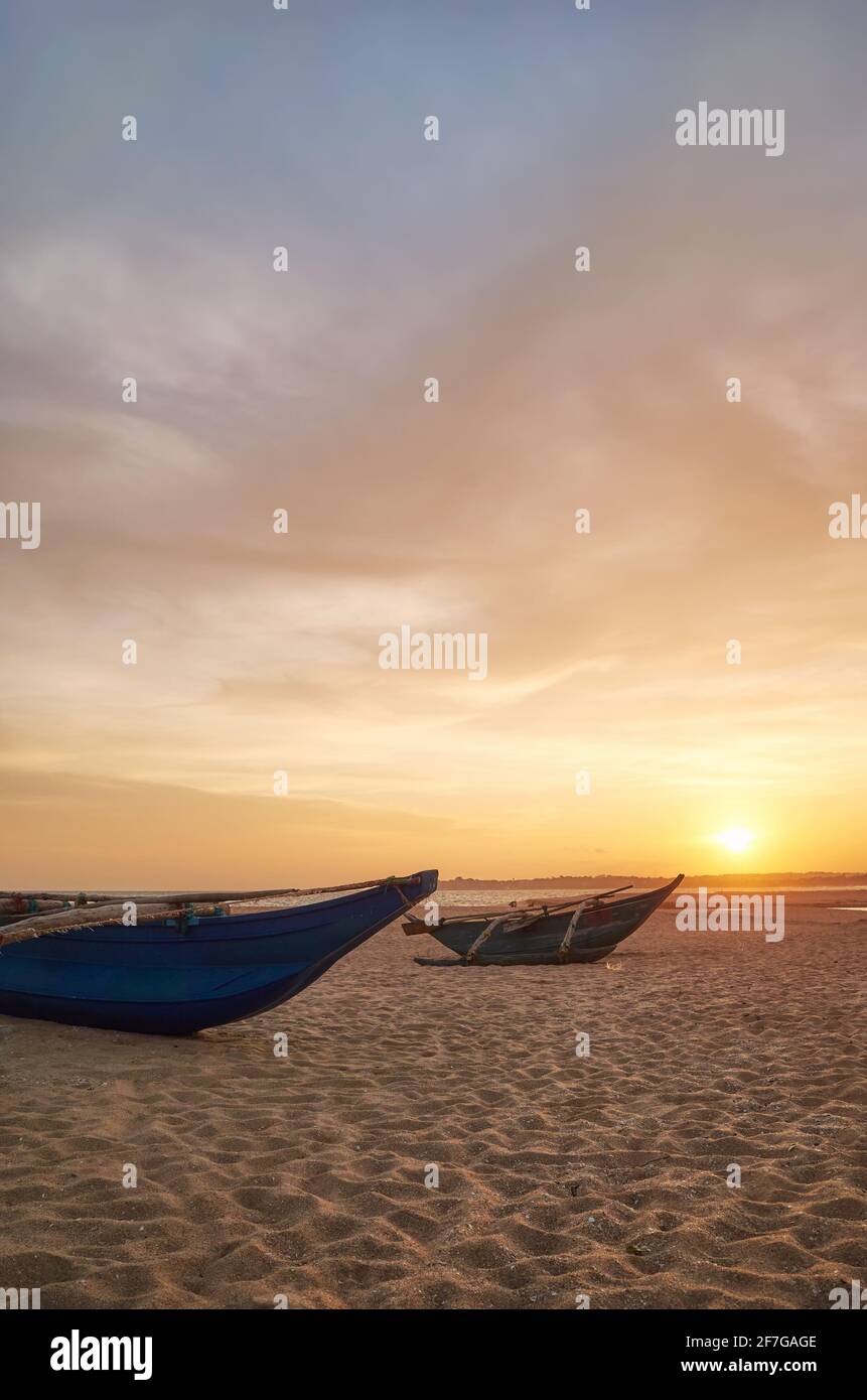 Piccole barche su una spiaggia vuota al tramonto, Sri Lanka. Foto Stock