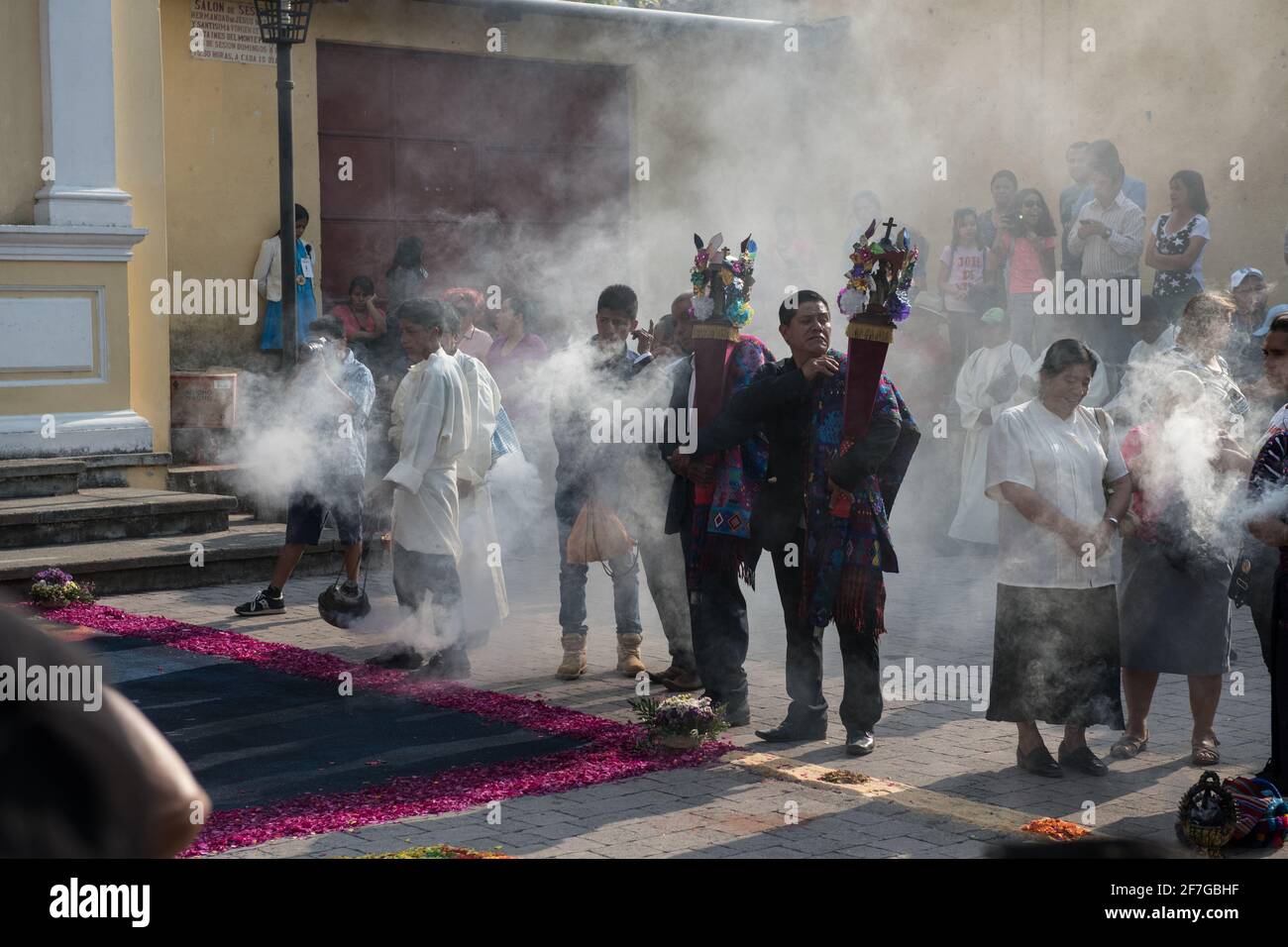 Le donne indigene guatemalteche in abiti tradizionali bruciano incenso durante la processione Semana Santa ad Antigua, un solenne rituale intriso di storia. Foto Stock
