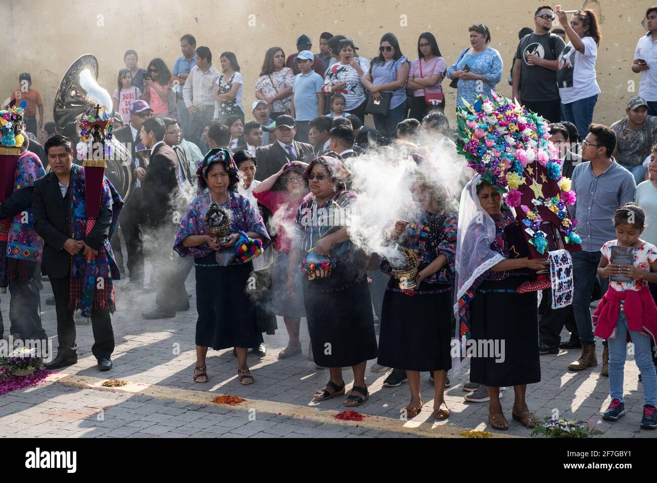 Le donne indigene guatemalteche in abiti tradizionali bruciano incenso durante la processione Semana Santa ad Antigua, un solenne rituale intriso di storia. Foto Stock