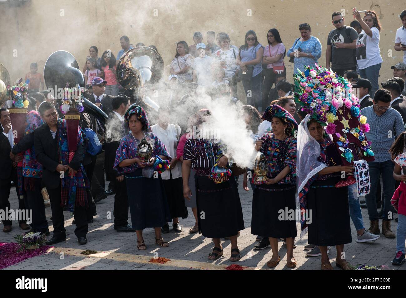 Le donne indigene guatemalteche in abiti tradizionali bruciano incenso durante la processione Semana Santa ad Antigua, un solenne rituale intriso di storia. Foto Stock