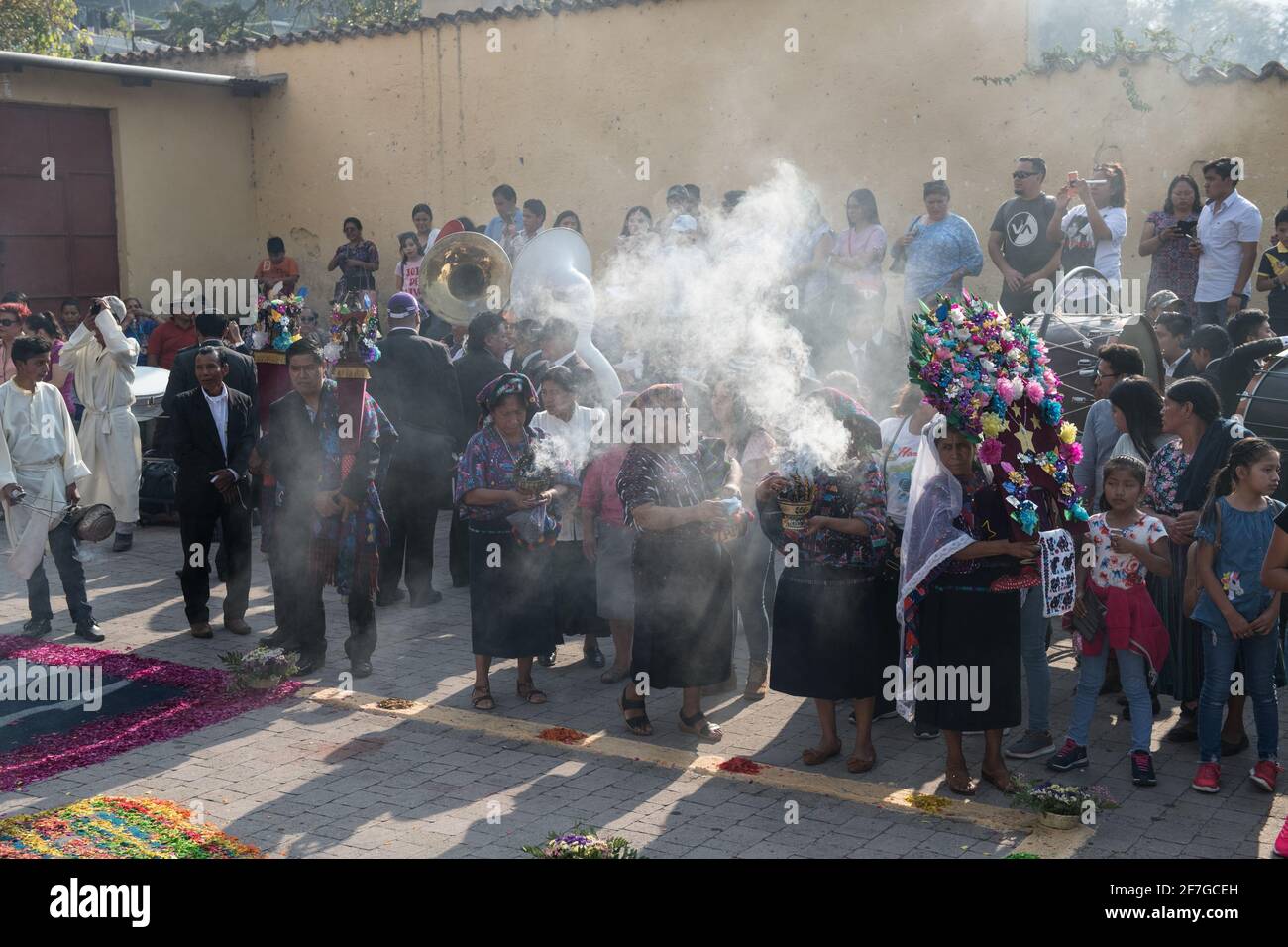 Le donne indigene guatemalteche in abiti tradizionali bruciano incenso durante la processione Semana Santa ad Antigua, un solenne rituale intriso di storia. Foto Stock
